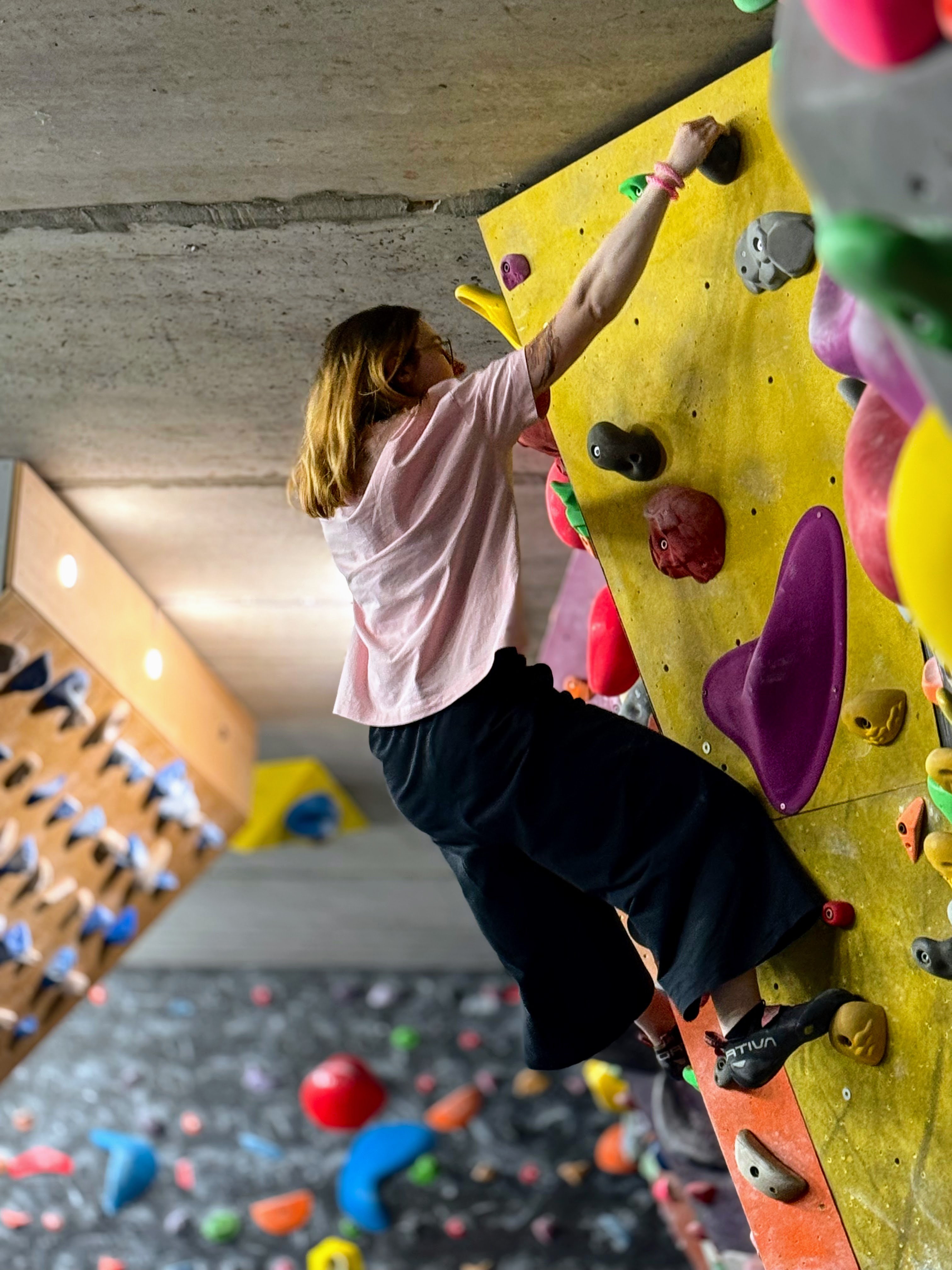 Young climber climbing yellow wall independently